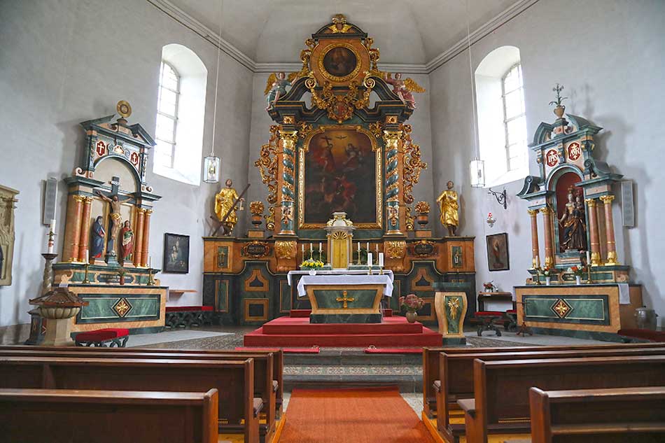 Der barocke, üppig verzierte Altar, rechts davon der Marienaltar, links der Kreuzaltar
